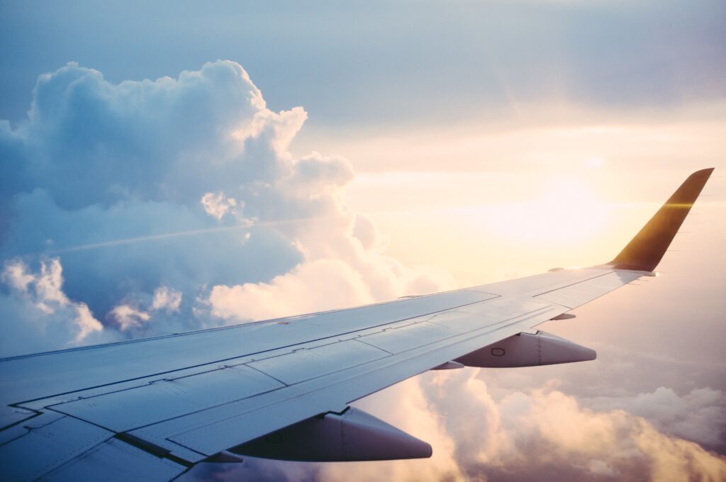 Plane flying through the clouds during sunrise. Travel pictures.