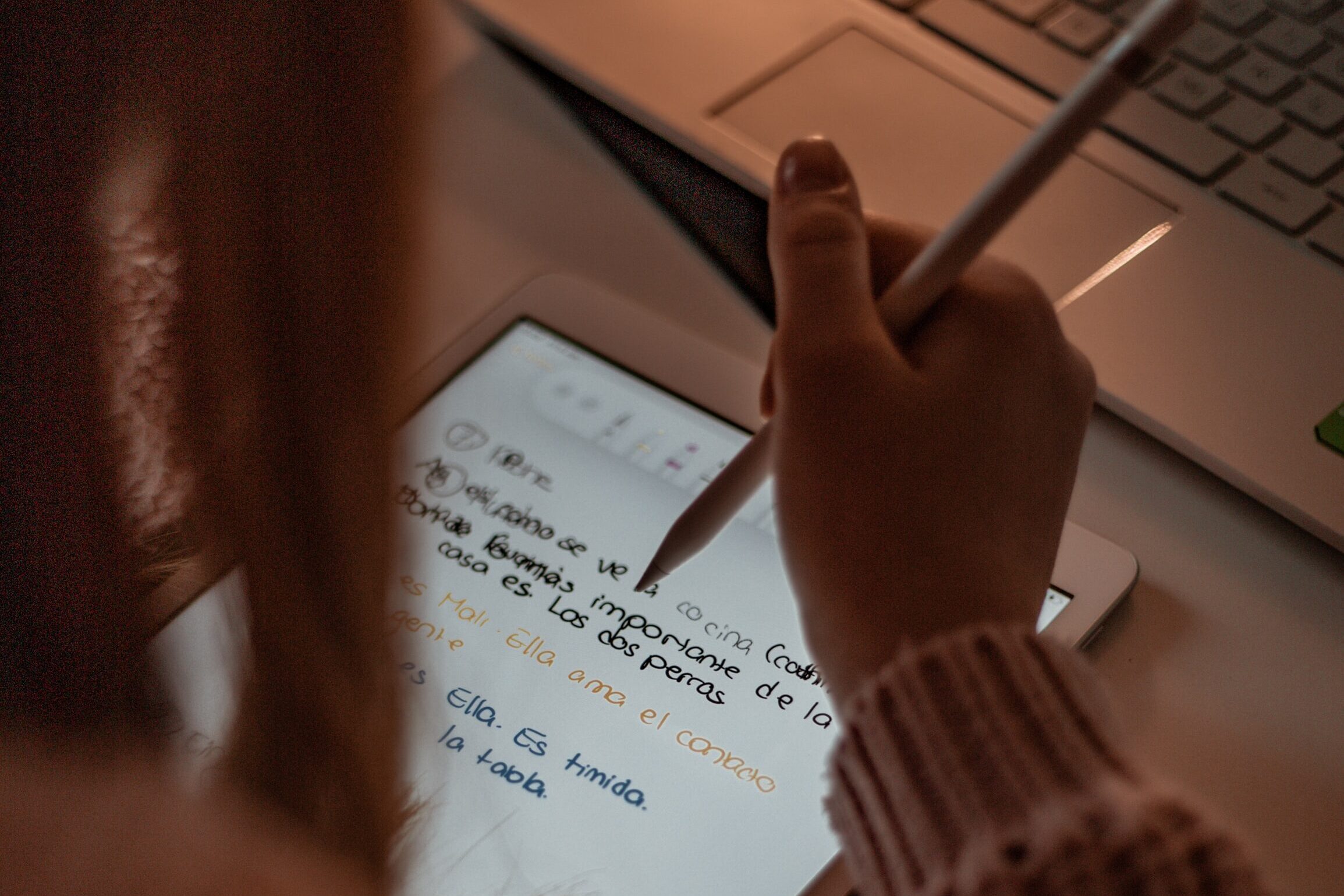 Woman learning Spanish online. Woman taking notes on an online Spanish app. 